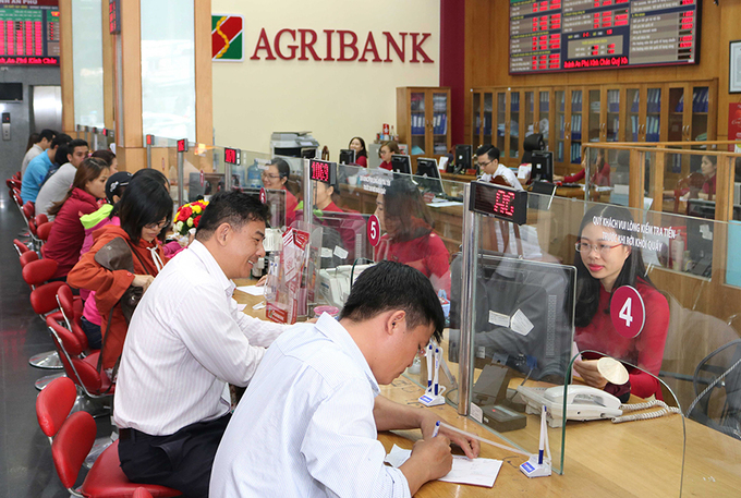 Nhân viên Agribank hỗ trợ khách hàng giao dịch tại quầy. Ảnh: Agribank.